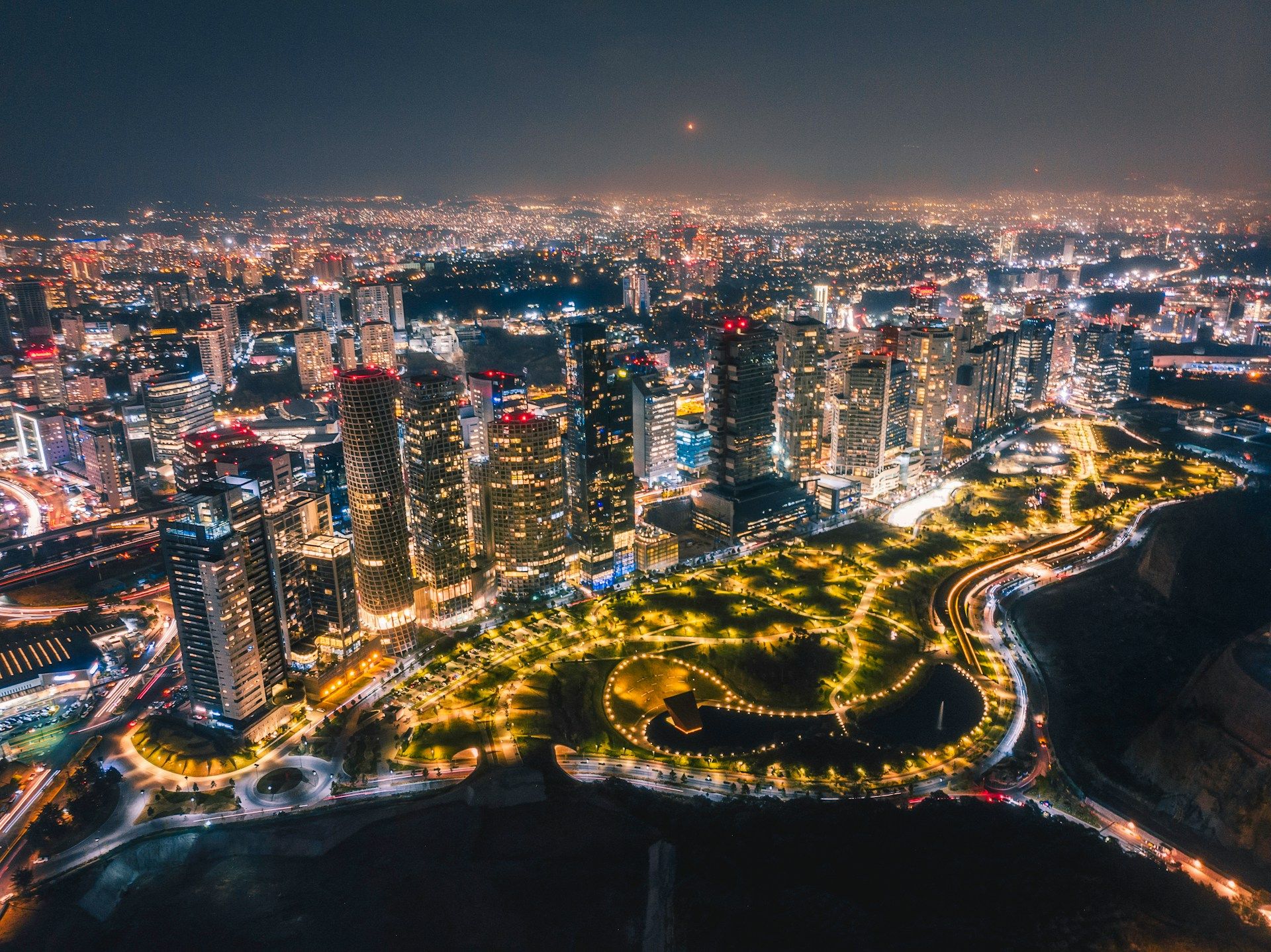 Toma aérea nocturna de rascacielos iluminados en la Ciudad de México